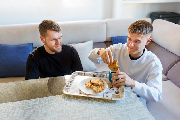 Hermanos disfrutando juntos de café y galletas