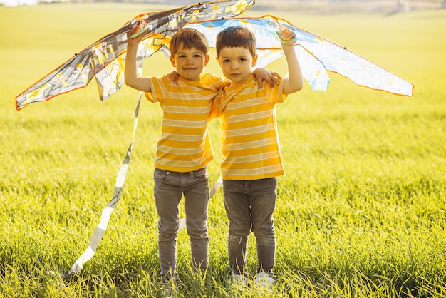 Hermanos divirtiéndose en el campo jugando con cometa