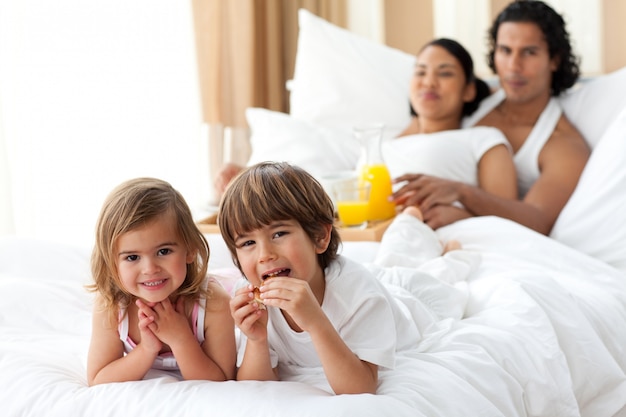 Hermanos felices desayunando con sus padres