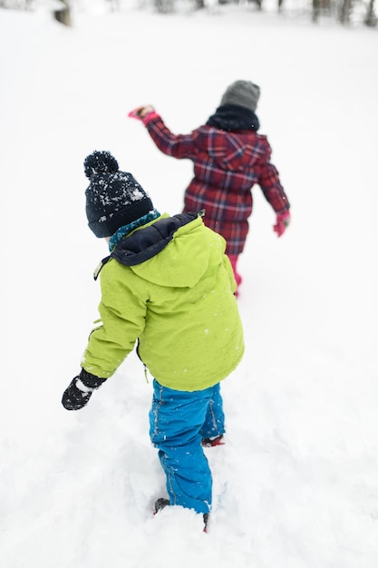 Hermanos felices divirtiéndose con la nieve