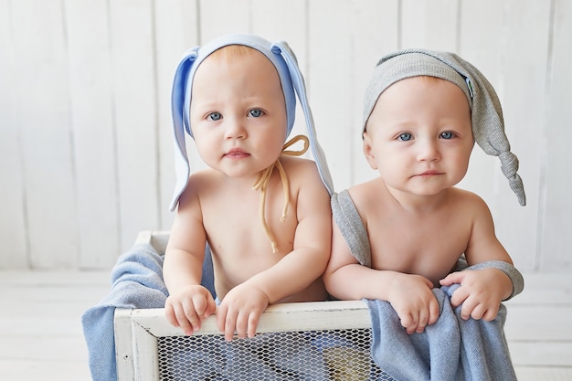 hermanos gemelos con divertidos sombreros en la cuna