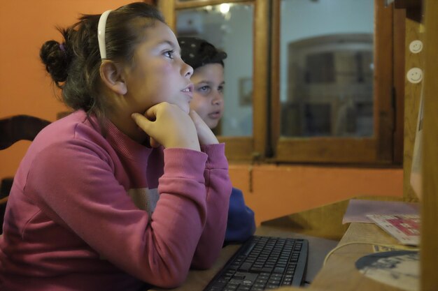 Hermanos y hermanas usando la computadora en casa