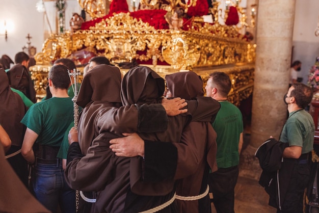 Hermanos de la hermandad abrazados con emoción