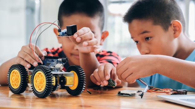 Foto hermanos jugando con un coche de juguete en la mesa