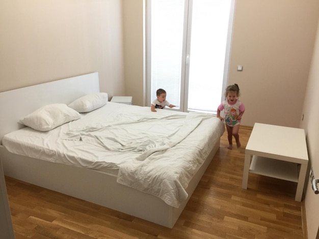 Hermanos jugando en el dormitorio en casa.