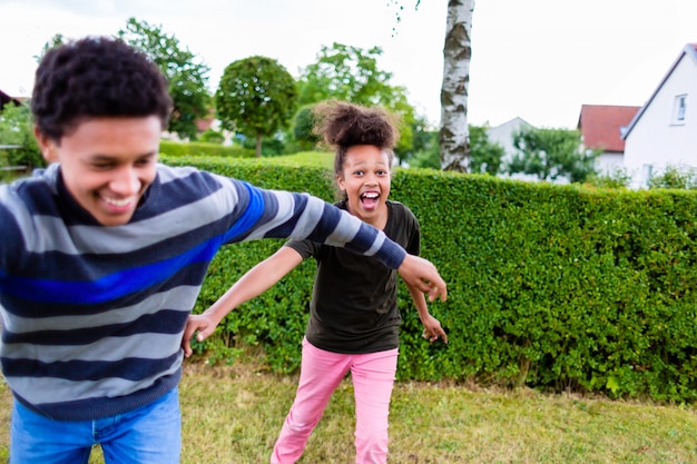 Hermanos jugando en el jardín