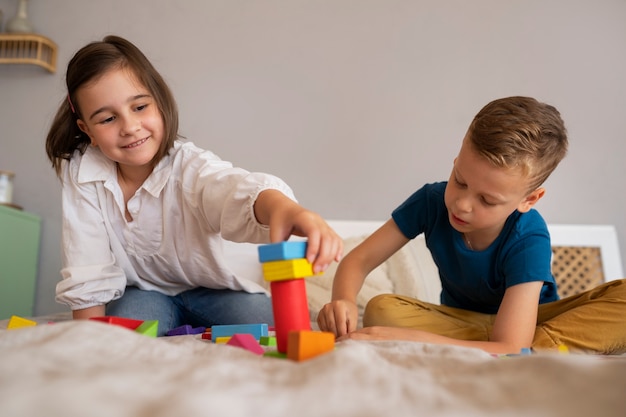 Foto hermanos jugando con juguetes de acertijo