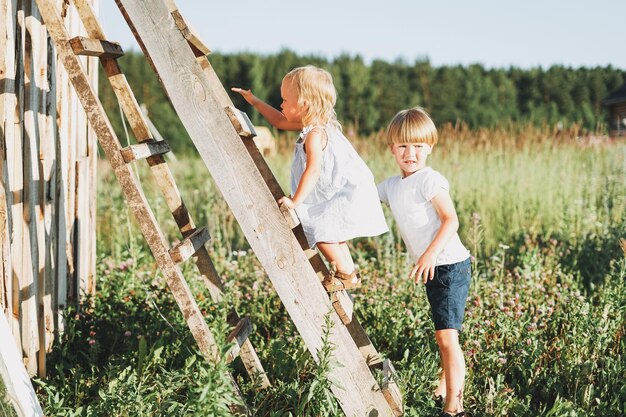 Hermanos lindos niña y niño hermano hermana sube la escalera campo cottagecor