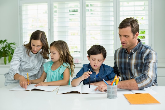 Los hermanos reciben ayuda de los padres con la tarea