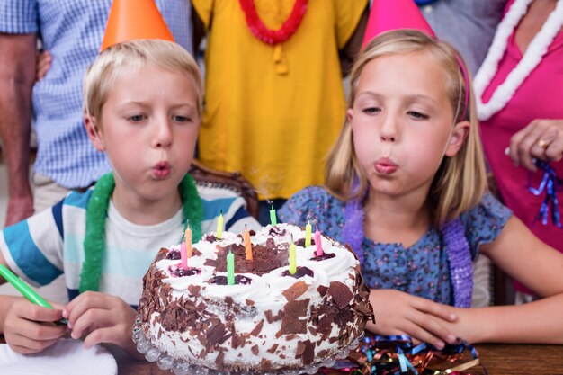 Hermanos soplando las velas en la fiesta de cumpleaños