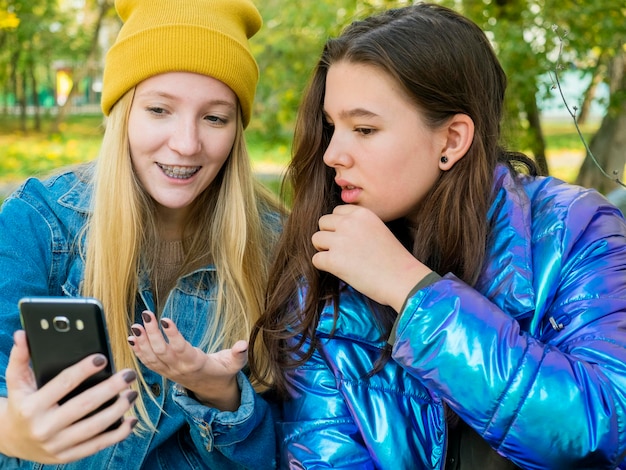 Foto hermanos con teléfonos inteligentes en el parque