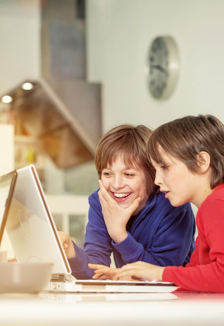 Foto hermanos usando la computadora portátil mientras están sentados en casa