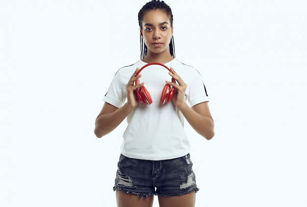 Hermosa adolescente africana con rastas en ropa deportiva escuchando música