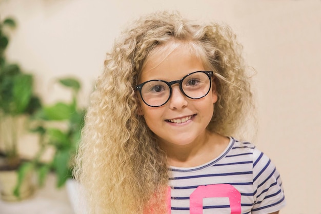 hermosa adolescente con cabello rizado y gafas se ríe