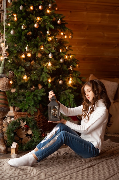 hermosa adolescente en casa cerca del árbol de navidad