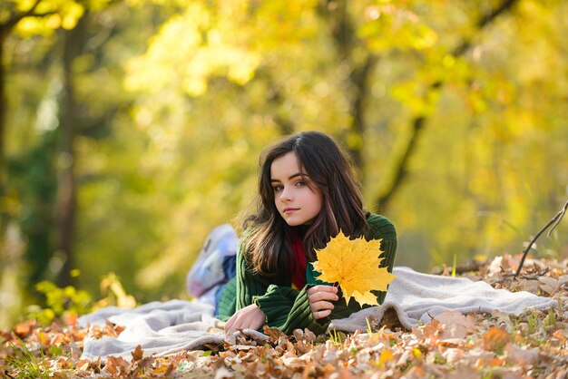 Hermosa adolescente divirtiéndose en el parque de otoño al aire libre