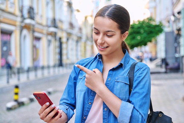 Hermosa adolescente hablando con fondo urbano de teléfono inteligente