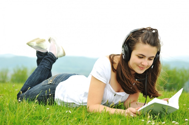 Hermosa adolescente leyendo un libro en la naturaleza