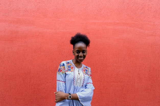 La hermosa afroamericana contra la pared roja