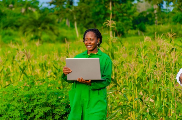 Una hermosa agricultora africana emocionada por lo que vio en su computadora portátil