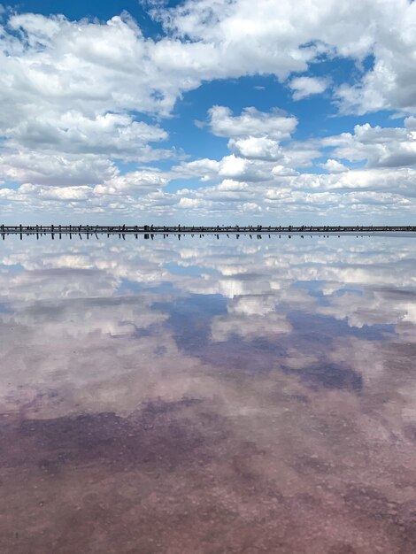 Hermosa agua en el lago salado rosa refleja las nubes y el cielo