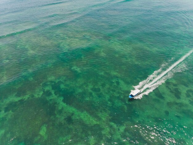 hermosa agua del océano turquesa con un barco en ella vista superior foto aérea