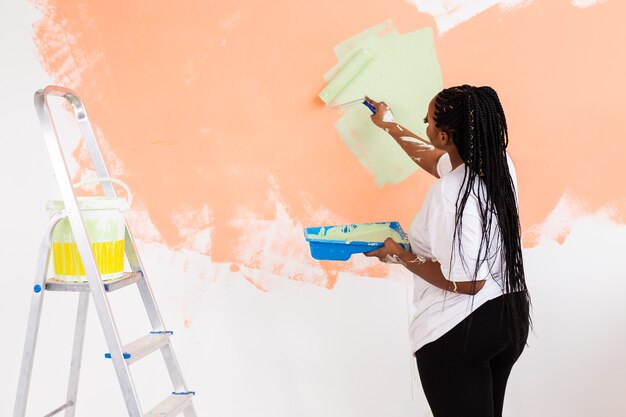 Hermosa ama de casa pintando la pared