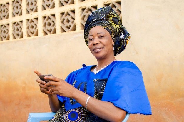 Hermosa anciana sonriendo mientras sostiene su teléfono