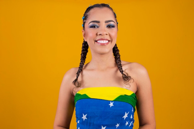 Hermosa animadora brasileña con peinado trenzado y maquillaje colorido para el juego de Brasil Copa del Mundo y maquillaje Linda chica vestida para el juego de Brasil