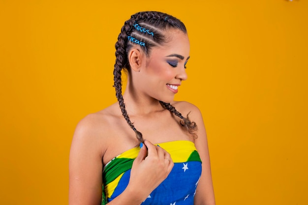 Foto hermosa animadora brasileña con peinado trenzado y maquillaje colorido para el juego de brasil copa del mundo y maquillaje linda chica vestida para el juego de brasil