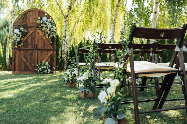 Una hermosa área para una ceremonia de boda al aire libre Arco Decorado con una gran puerta de madera con muchas flores