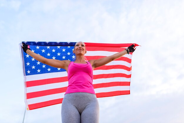 Foto hermosa atleta estadounidense con bandera nacional.