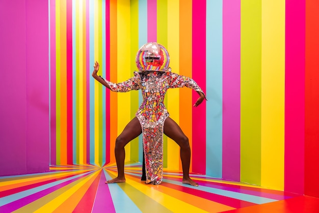 Hermosa bailarina joven afroamericana divirtiéndose dentro de una sala de caja de arco iris