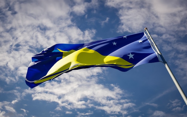 Hermosa bandera del estado nacional de Tokelau ondeando en el cielo azul