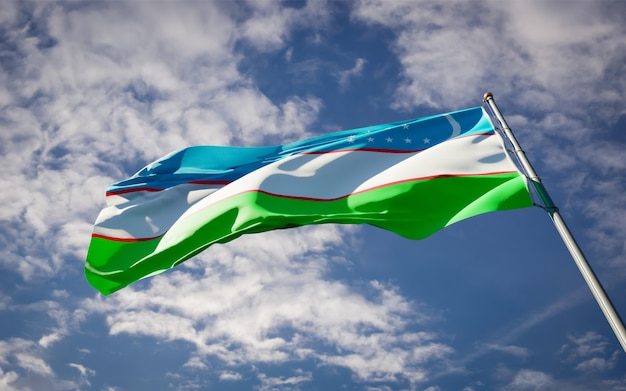 Hermosa bandera del estado nacional de Uzbekistán ondeando en el cielo azul