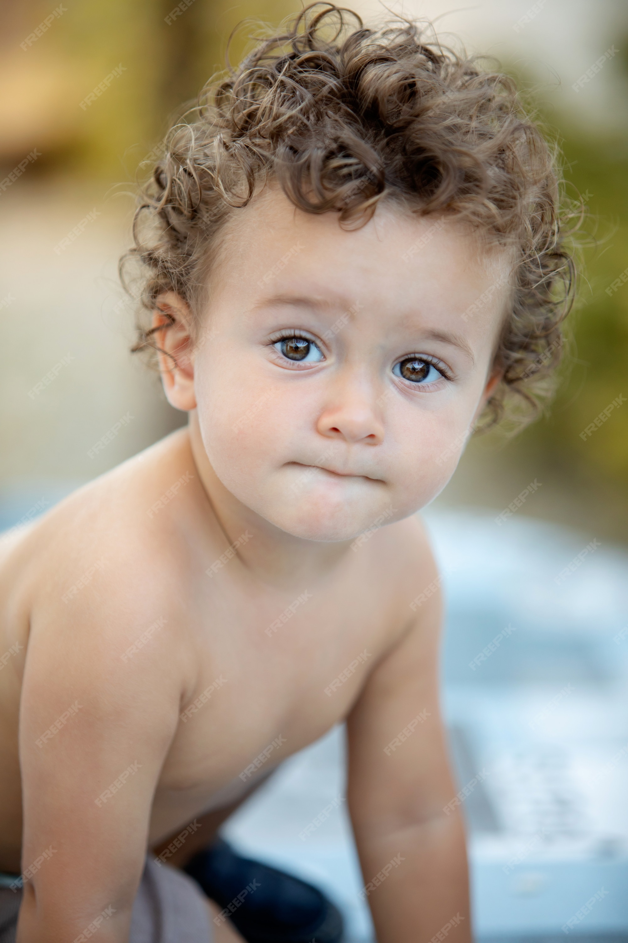 Hermosa bebe con pelo rizado el jardin. Foto Premium