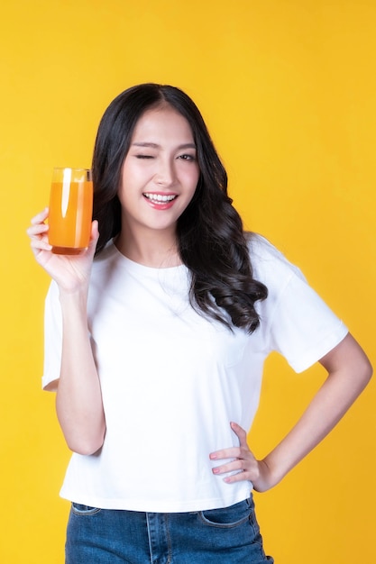 Hermosa belleza mujer asiática linda chica se siente feliz bebiendo jugo de naranja para una buena salud sobre fondo blanco - estilo de vida belleza mujer concepto saludable