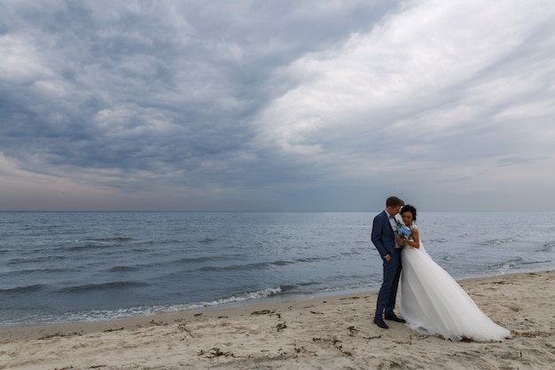 Hermosa boda feliz pareja novia y novio en el día de la boda al aire libre en la playa