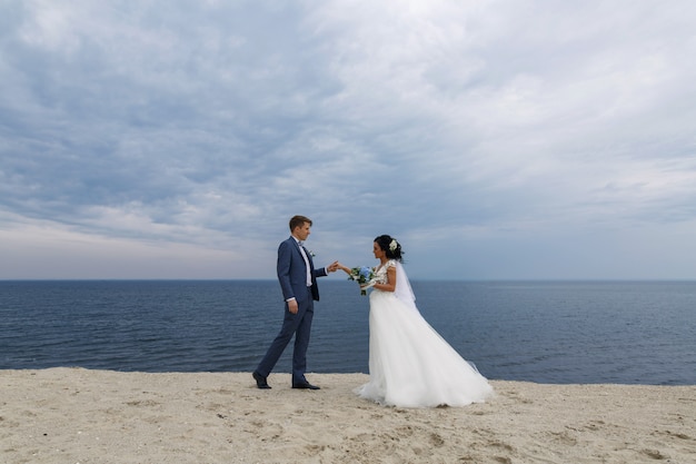 Hermosa boda feliz pareja novia y novio en el día de la boda al aire libre en la playa