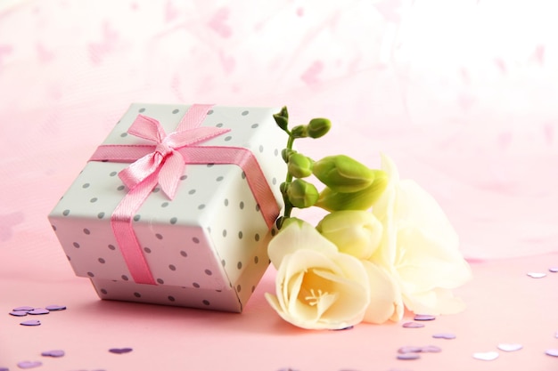 Hermosa caja de regalo romántico y flor sobre fondo rosa