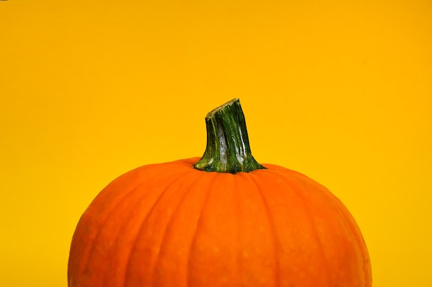 Una hermosa calabaza naranja está aislada sobre un fondo amarillo Preparación para la fiesta de Halloween