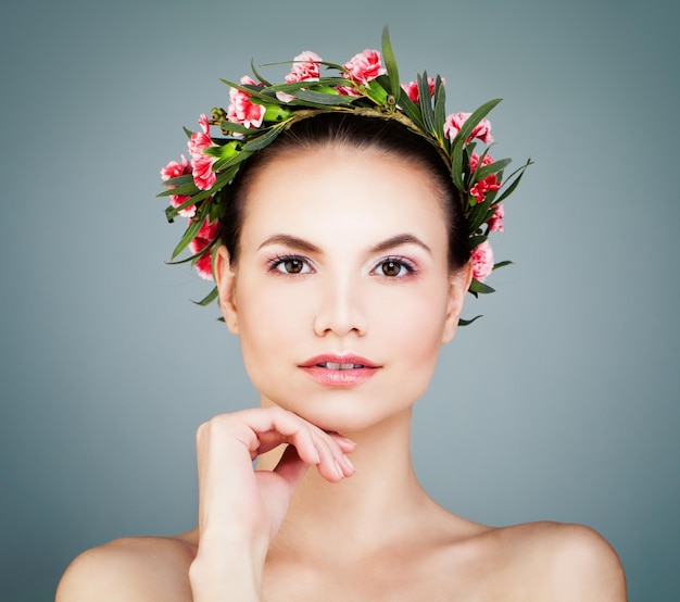 Hermosa cara femenina Spa modelo mujer con piel sana y corona de flores