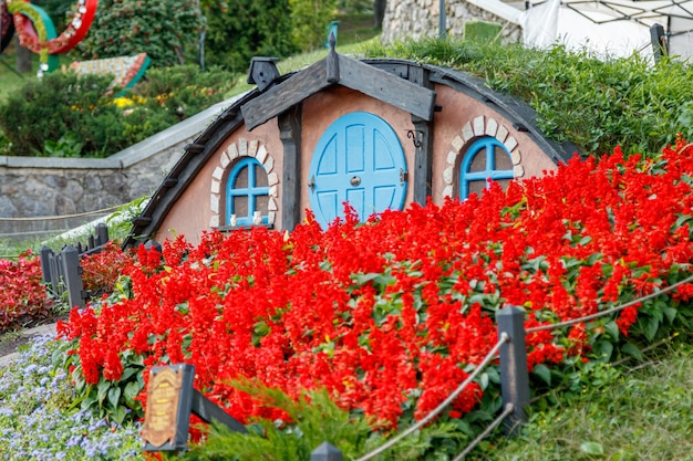 Hermosa casa de cuento de hadas con flores de césped