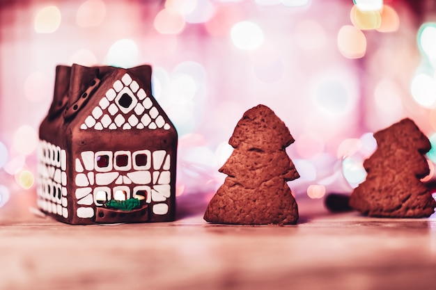 hermosa casa de pan de jengibre y pan de jengibre comido en el fondo de Navidad. la foto tiene un espacio vacío para tu texto