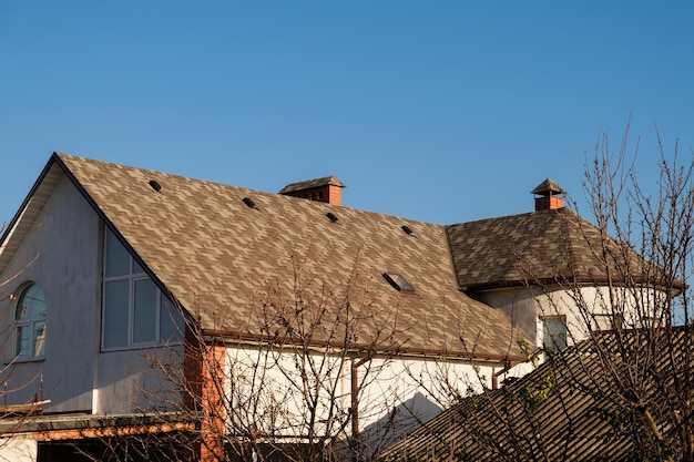 Una hermosa casa con techo de tejas bituminosas.