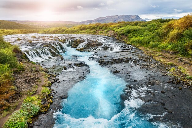 Hermosa cascada de Bruarfoss con agua turquesa al atardecer. Al sur de islandia