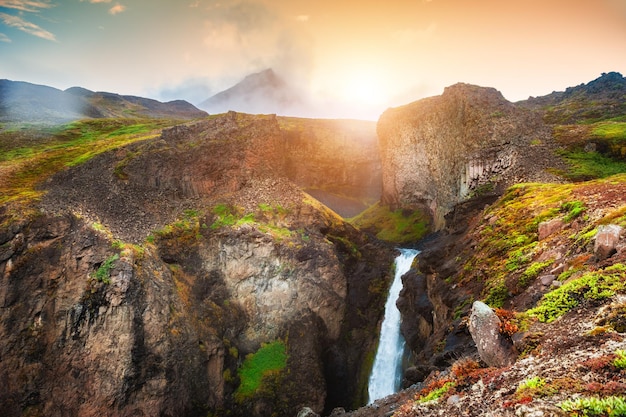 Hermosa cascada en las montañas al atardecer. Isla Disco, costa oeste de Groenlandia