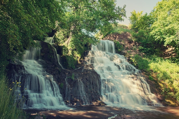 Hermosa cascada de selva tropical de montaña con agua que fluye rápidamente y rocas de larga exposición Fondo natural de viajes estacionales al aire libre en estilo vintage hipster