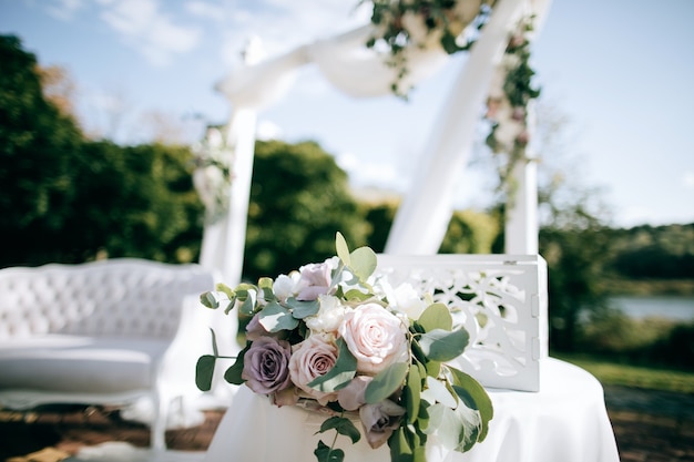 Hermosa ceremonia de boda en la orilla del lago y arco con flores frescas