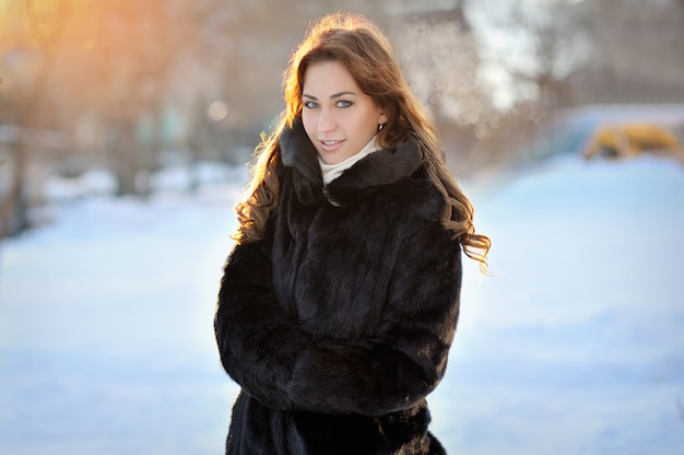Hermosa chica en abrigo de invierno marrón en la calle